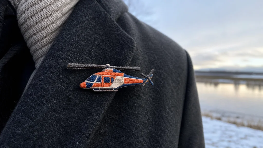 Broche brodée en forme d'hélicoptère de sauvetage sur un manteau de laine